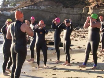 On the beach at dawn, Insulindependence Captains prepare to brave the chilly Pacific Ocean.