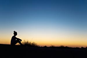 shutterstock_204231226_woman_sitting_beach_sunrise_300px